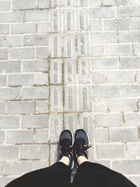 Low section of person standing on tiled floor
