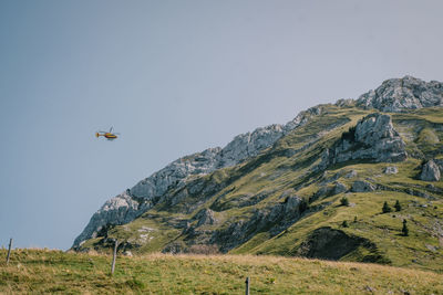 Airplane flying over mountains against clear sky