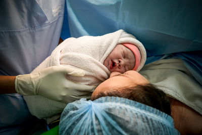 Doctor holding baby with mother at hospital