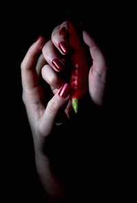 Close-up of woman hand over black background