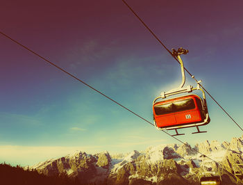 Low angle view of overhead cable car against sky