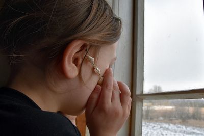 Close-up portrait of woman holding glass window