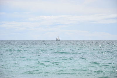 Sailboat sailing on sea against sky