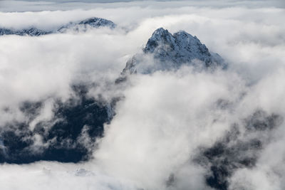 Low angle view of clouds covering mountain against sky