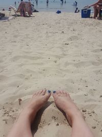 Low section of person on sand at beach