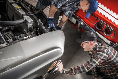 Side view of mechanic repairing car