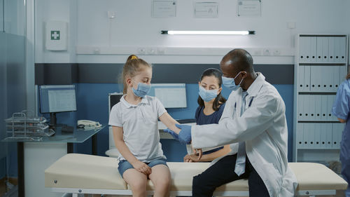 Doctor examining girl in clinic