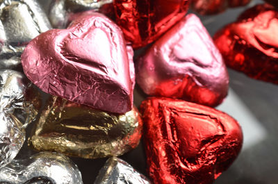 Close up of pink, red, and silver foil wrapped milk chocolate candy hearts