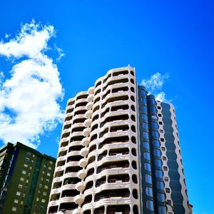 Low angle view of modern building against blue sky