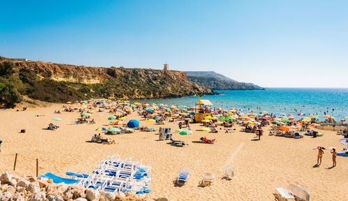 High angle view of people at beach against clear sky on sunny day