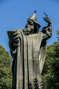 Low angle view of angel statue against clear blue sky