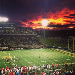 Panoramic view of crowd at park against sky during sunset