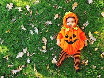 High angle view of baby in pumpkin costume