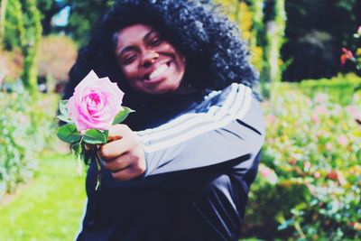 Close-up of woman holding pink rose