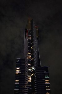 Low angle view of illuminated buildings against sky at night