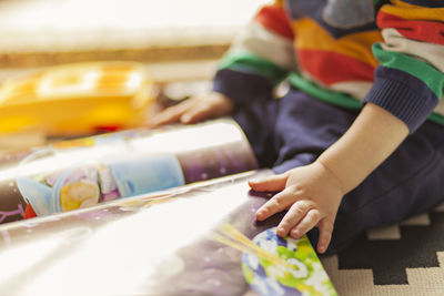 Close-up of boy holding multi colored pencils on table