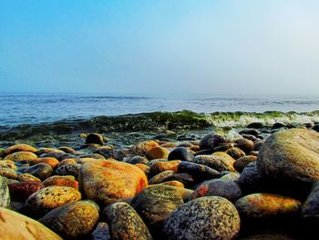 Rocks in sea against clear sky