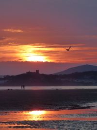 Scenic view of sea against orange sky