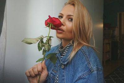 Close-up of woman holding rose at home