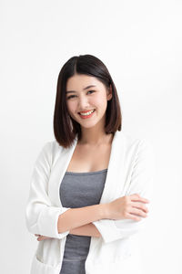 Portrait of a smiling young woman against white background