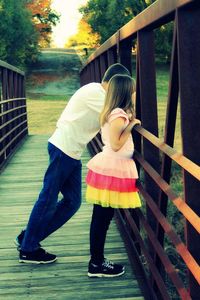 Full length of siblings standing on footbridge at public park