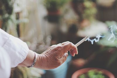 Cropped hand of woman holding cigarette