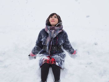 Full length of beautiful woman in snow on field