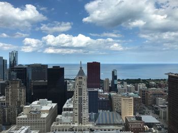 Aerial view of buildings in city against sky