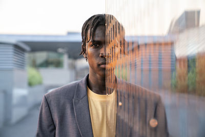 Young businessman in front of metal wall