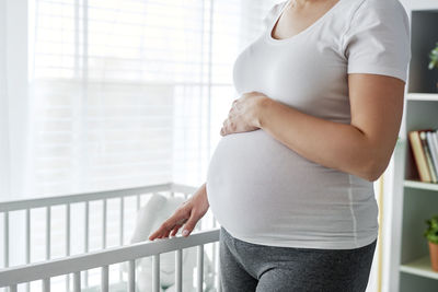 Midsection of woman touching mirror