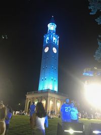 People on illuminated building at night