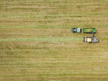 Aerial view of tractor on agricultural landscape during sunny day