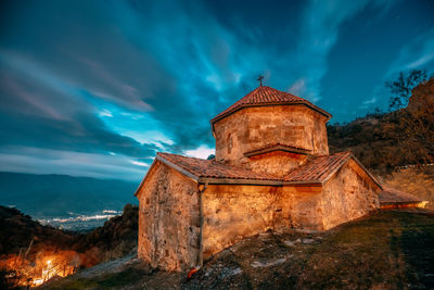 Low angle view of illuminated building against sky at dusk