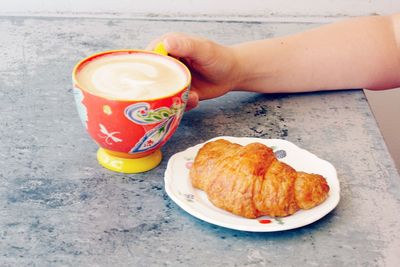 Cropped image of person having breakfast on table