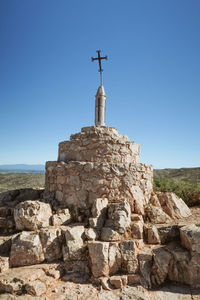 Low angle view of cross against clear blue sky