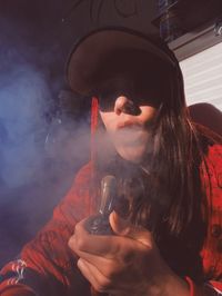 Portrait of woman holding smoking pipe