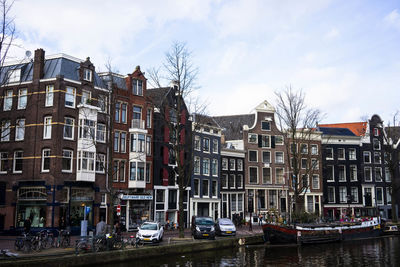 Cars on road by buildings against sky