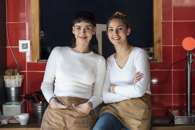 Smiling coworkers wearing apron in restaurant