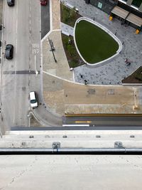 Looking down onto a road with cars and people walking 