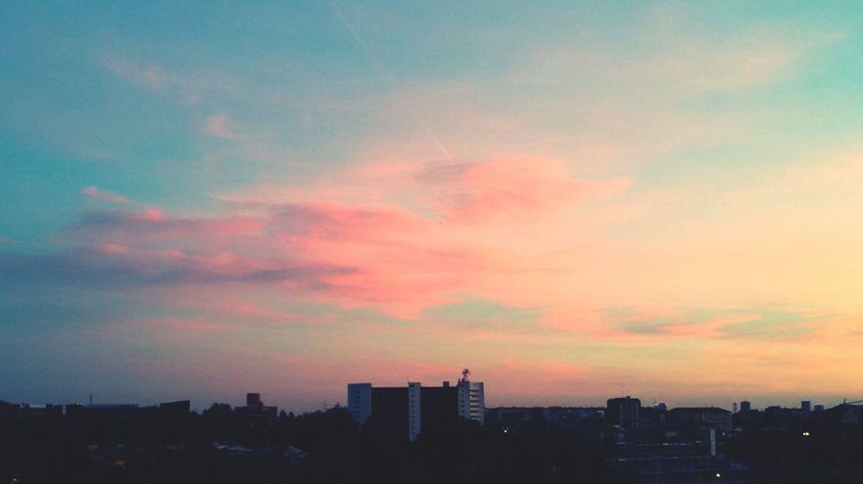 SILHOUETTE OF CITYSCAPE AGAINST CLOUDY SKY