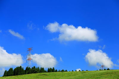 Low angle view of windmill on field against blue sky