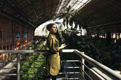 Portrait of young woman standing in building