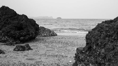 Rocks on beach against clear sky