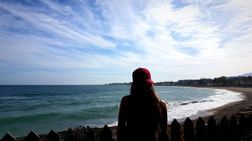 Rear view of woman looking at sea against sky