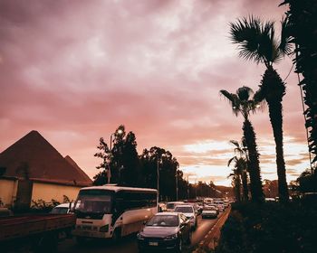 Cars on road against sky during sunset