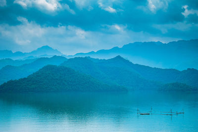 Scenic view of lake by mountains against sky