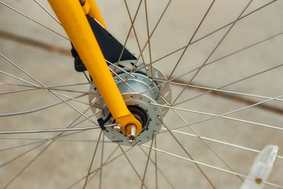 A close up of the hub, spokes, forks, and disc brake on a bicycle.