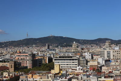 Houses in town against clear blue sky