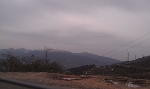 Scenic view of mountains against cloudy sky