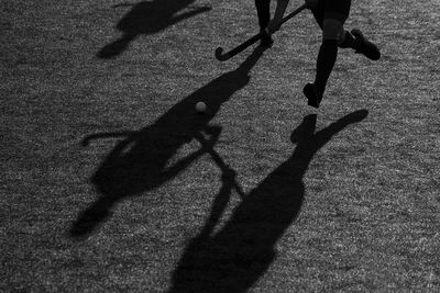 Low section of person playing hockey on road